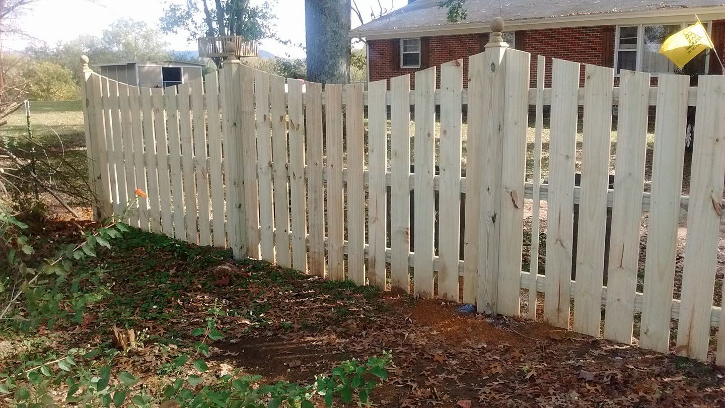Classic white wood picket fence bordering a front yard